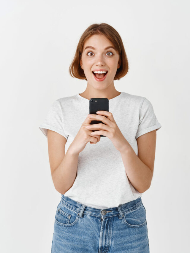 cropped-excited-pretty-girl-scream-with-joy-after-reading-phone-message-holding-smartphone-looking-amazed-checking-out-online-promo-white-wall-scaled-1.jpg