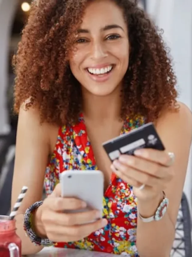 cropped-conceito-de-internet-banking-e-comercio-eletronico-mulher-jovem-feliz-e-sorridente-com-penteado-afro-usa-um-celular-moderno-e.webp