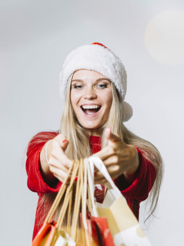 woman-in-santa-hat-with-colourful-shopping-bags-in-hands